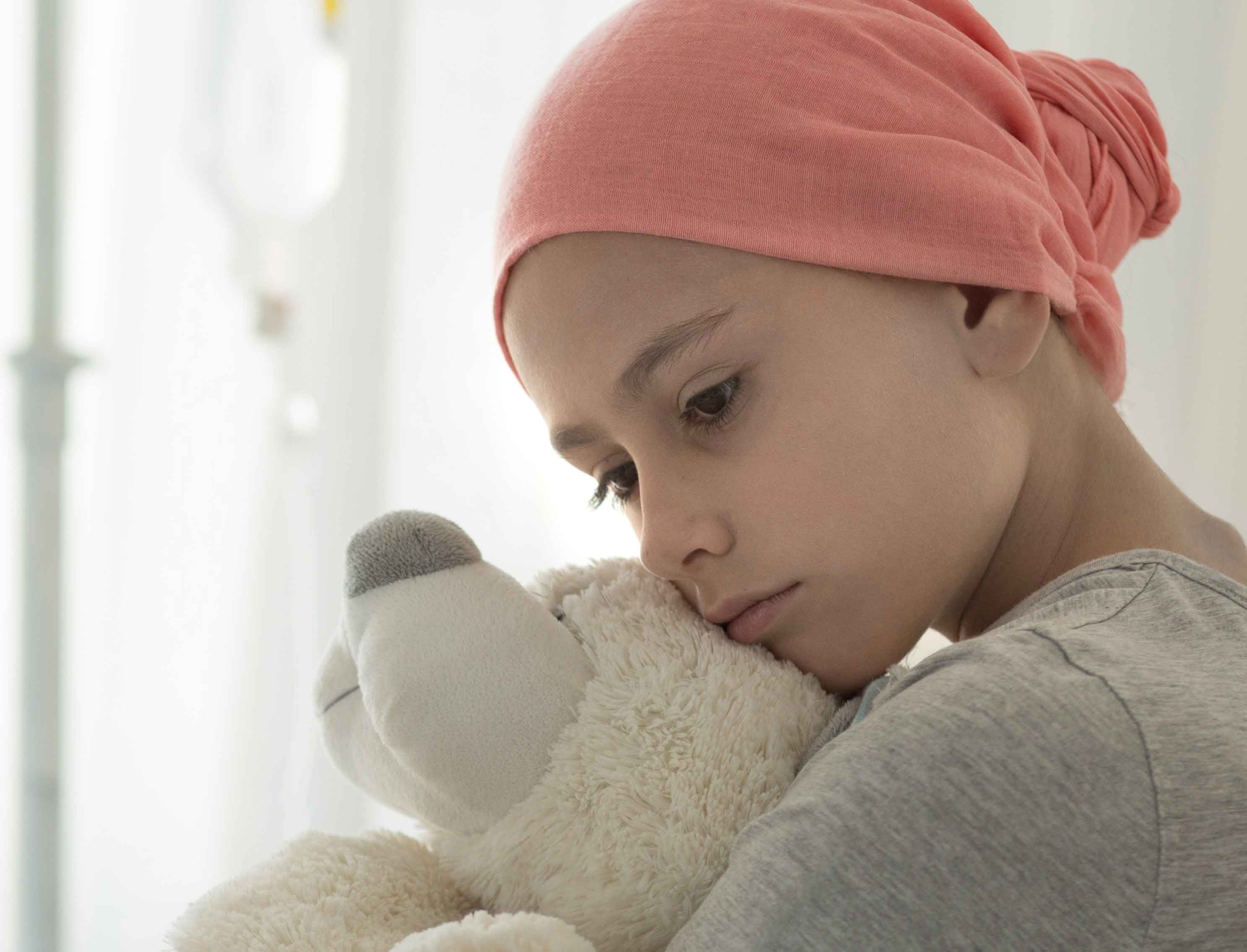 Weak Girl With Cancer Wearing Pink Headscarf And Hugging Teddy Bear